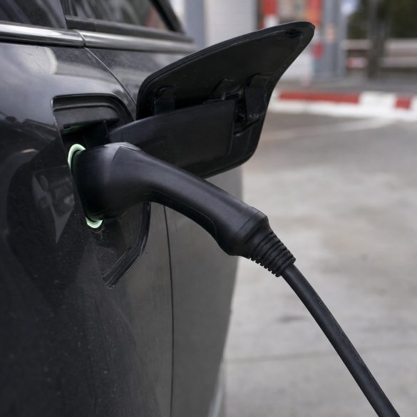 Cabo de recarga conectado à tomada de um carro elétrico em close